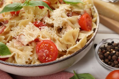 Photo of Plate of delicious pasta with tomatoes, basil and parmesan cheese on table, closeup