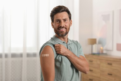 Man with sticking plaster on arm after vaccination at home