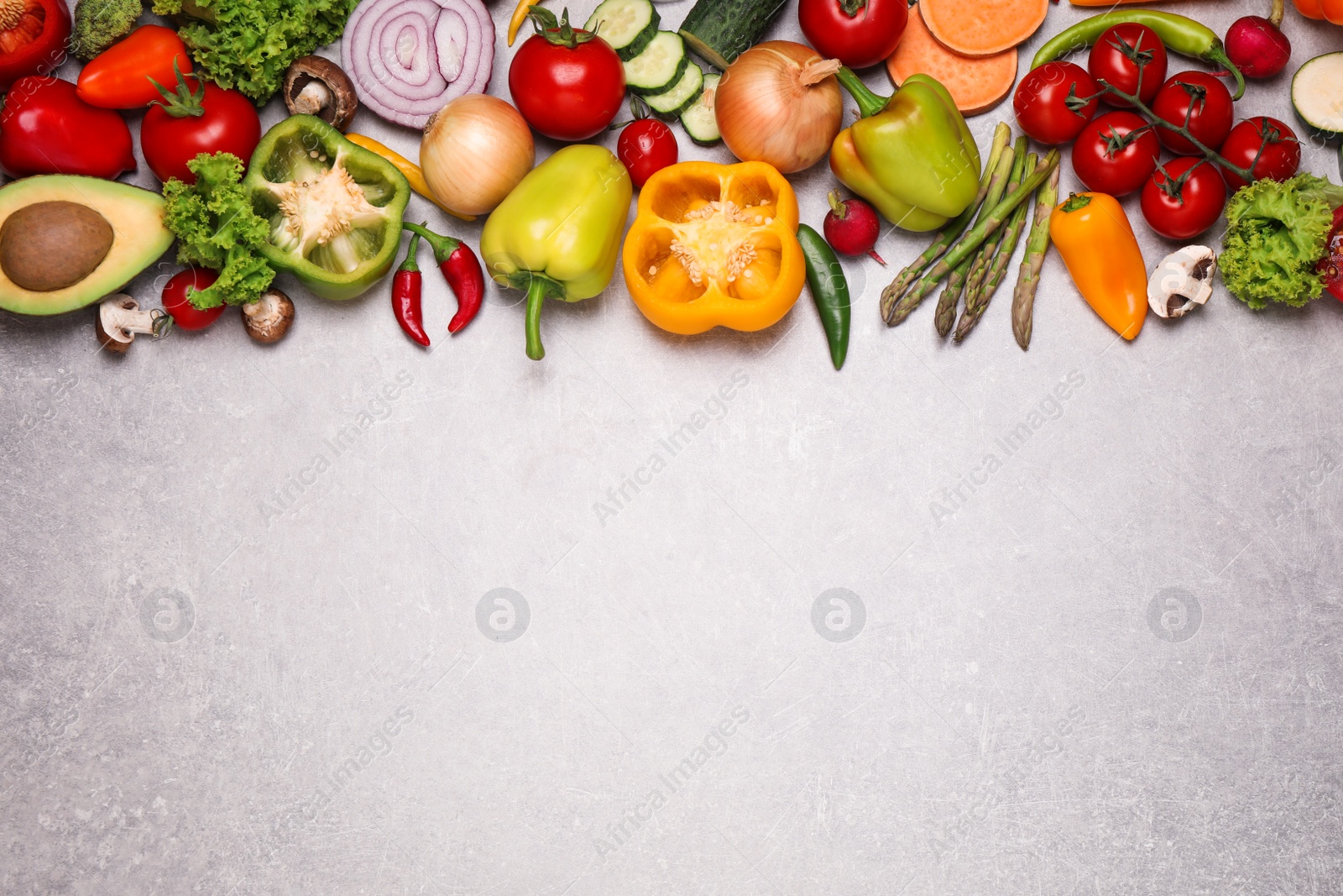 Photo of Flat lay composition with fresh vegetables on grey table. Space for text