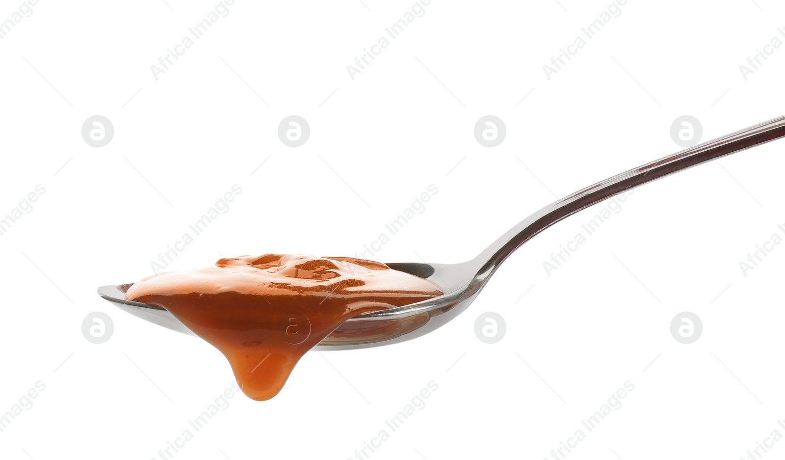 Photo of Spoon of tasty caramel sauce isolated on white