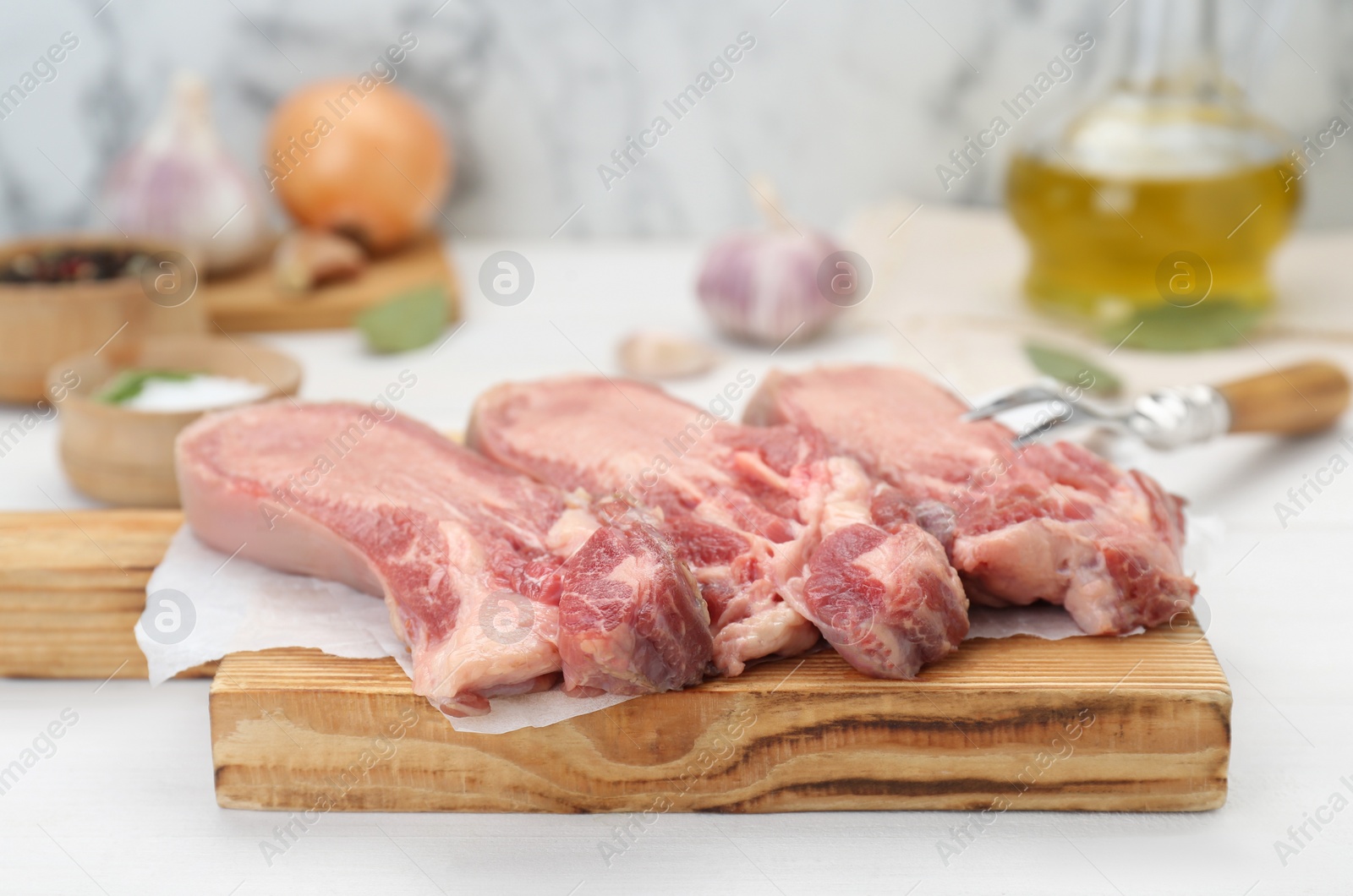 Photo of Raw beef tongue pieces on white wooden table, closeup