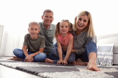 Photo of Happy family with children on floor at home