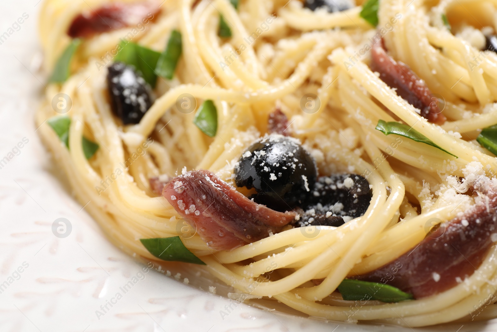 Photo of Delicious pasta with anchovies, olives and parmesan cheese, closeup