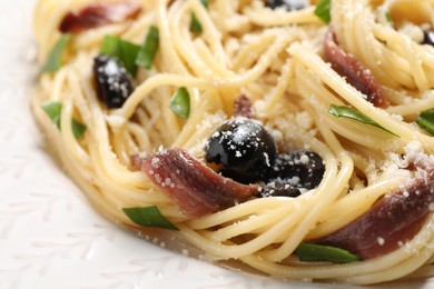 Delicious pasta with anchovies, olives and parmesan cheese, closeup