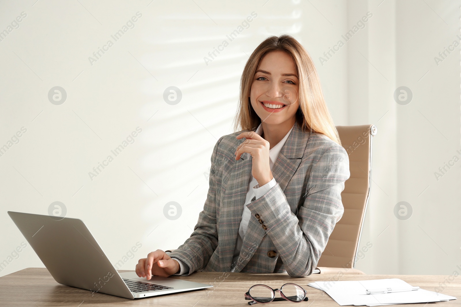 Photo of Portrait of beautiful young businesswoman with laptop at table in office