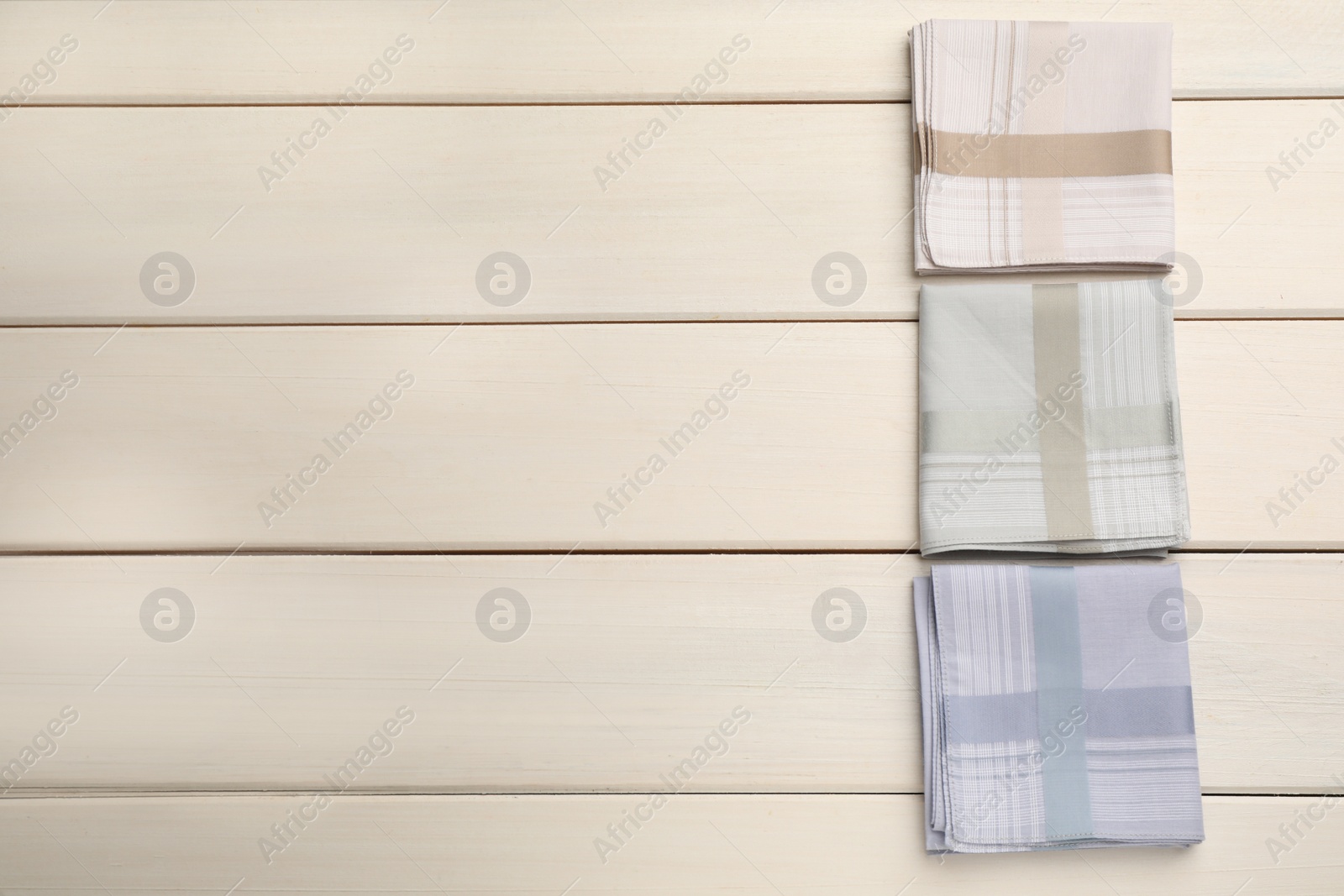 Photo of Stylish handkerchiefs on white wooden table, flat lay. Space for text