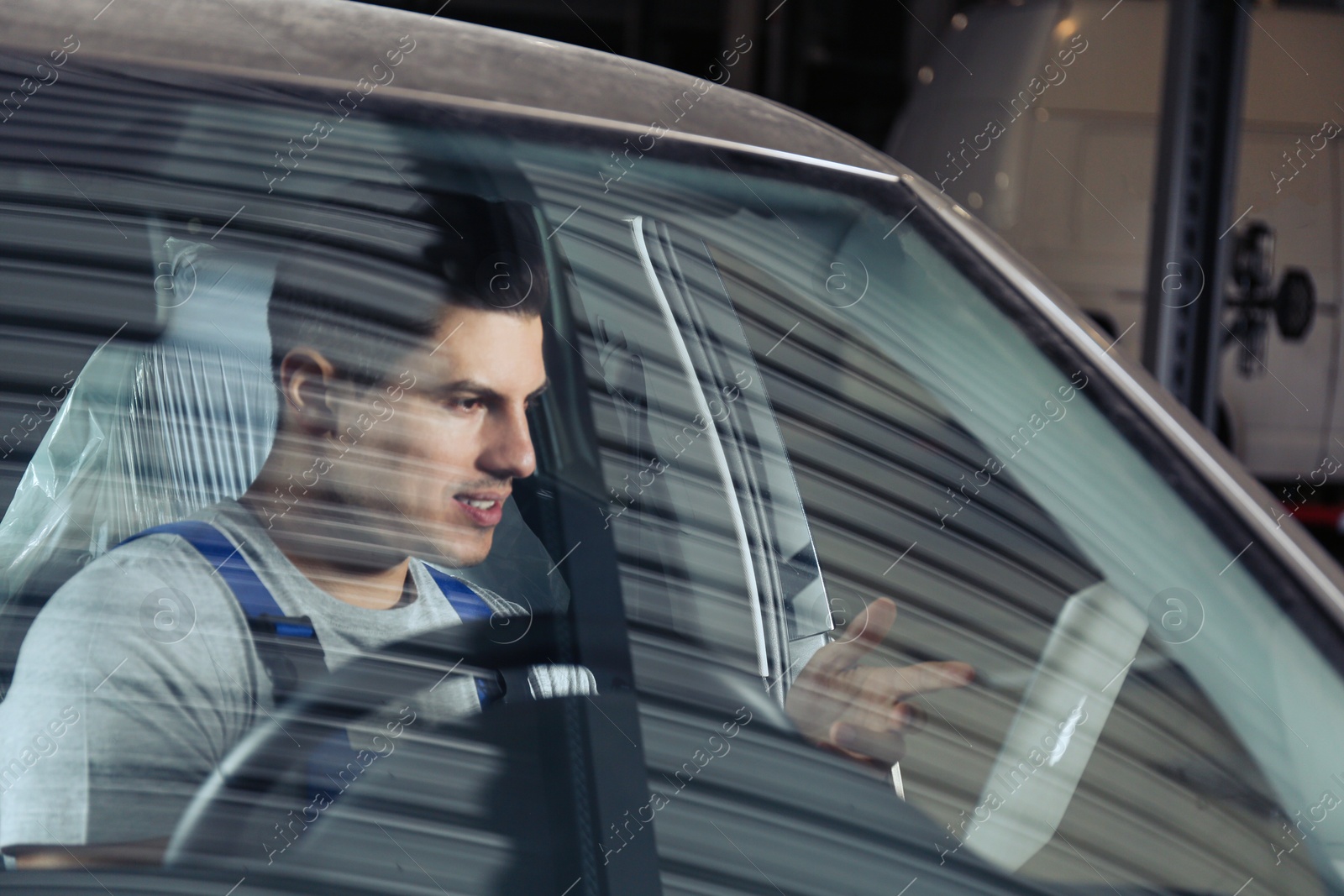 Photo of Mechanic with laptop doing car diagnostic at automobile repair shop