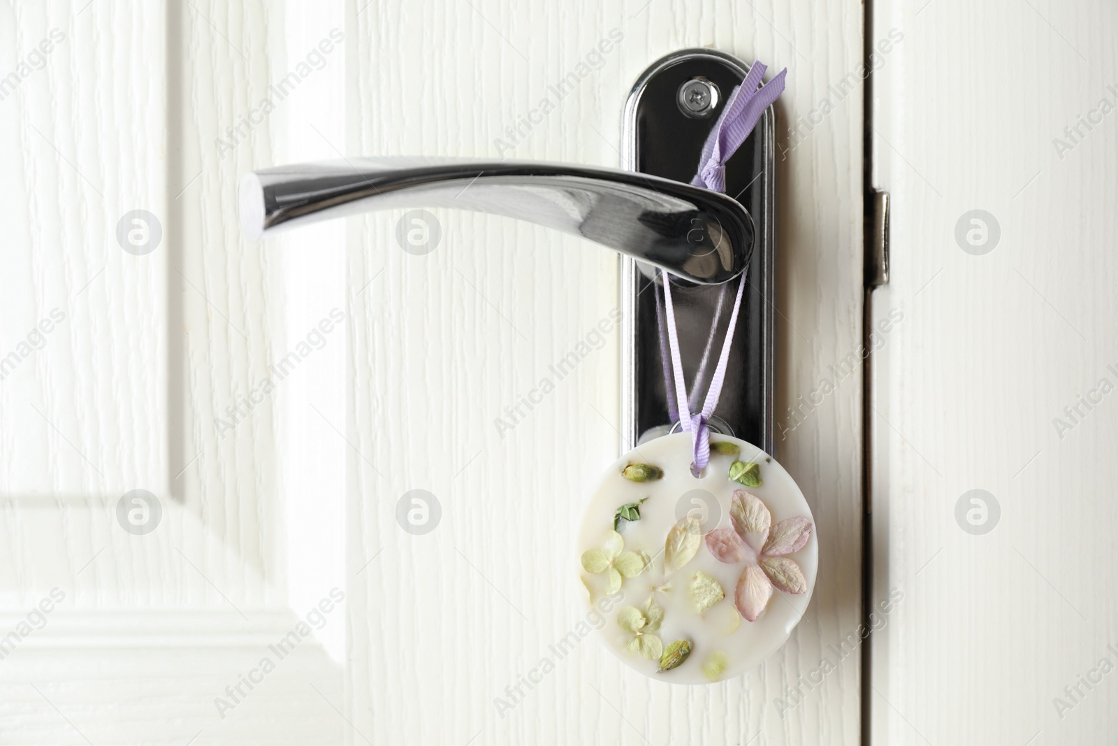 Photo of Scented sachet with flowers hanging on door handle