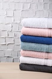 Photo of Stacked soft terry towels on wooden table