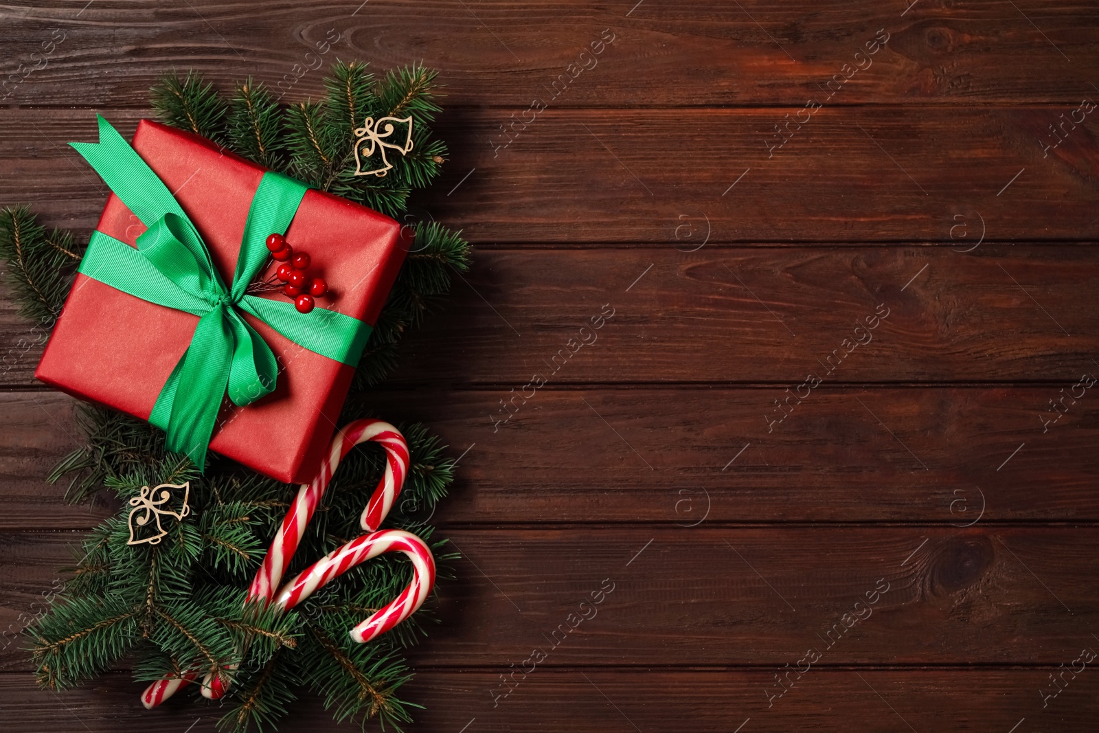 Photo of Christmas composition with gift box and festive decor on wooden table, flat lay. Space for text