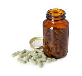 Photo of Vitamin pills and bottle isolated on white