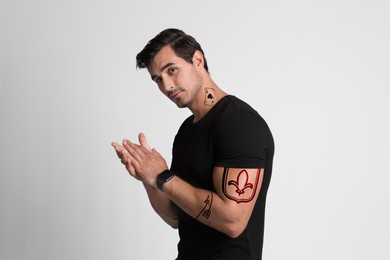 Image of Handsome man with beautiful tattoo sketches on white background