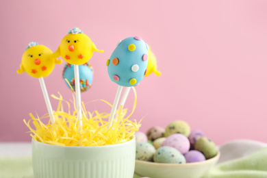 Photo of Closeup view of delicious sweet cake pops on pink background, space for text. Easter holiday