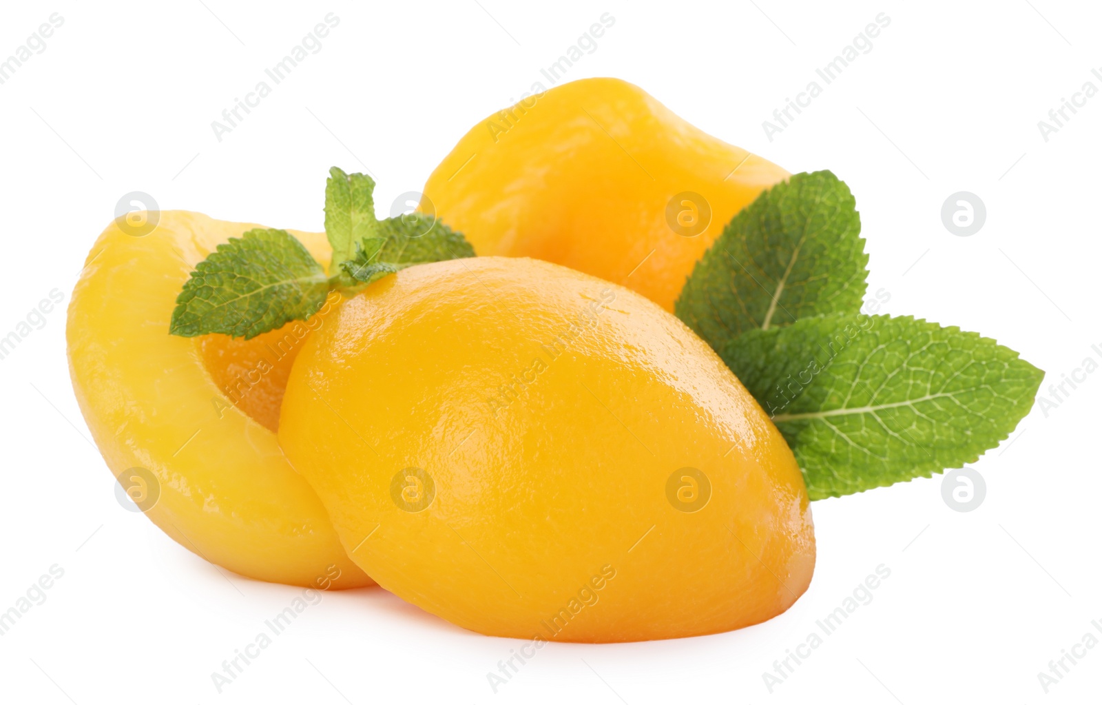 Photo of Sweet canned peach halves with mint isolated on white