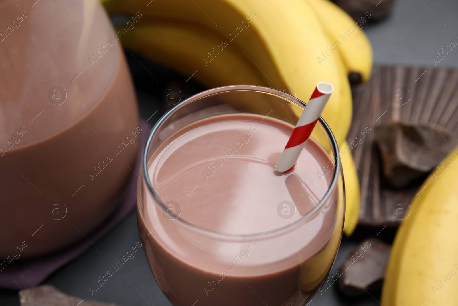 Photo of Fresh yummy chocolate milk on black table, closeup