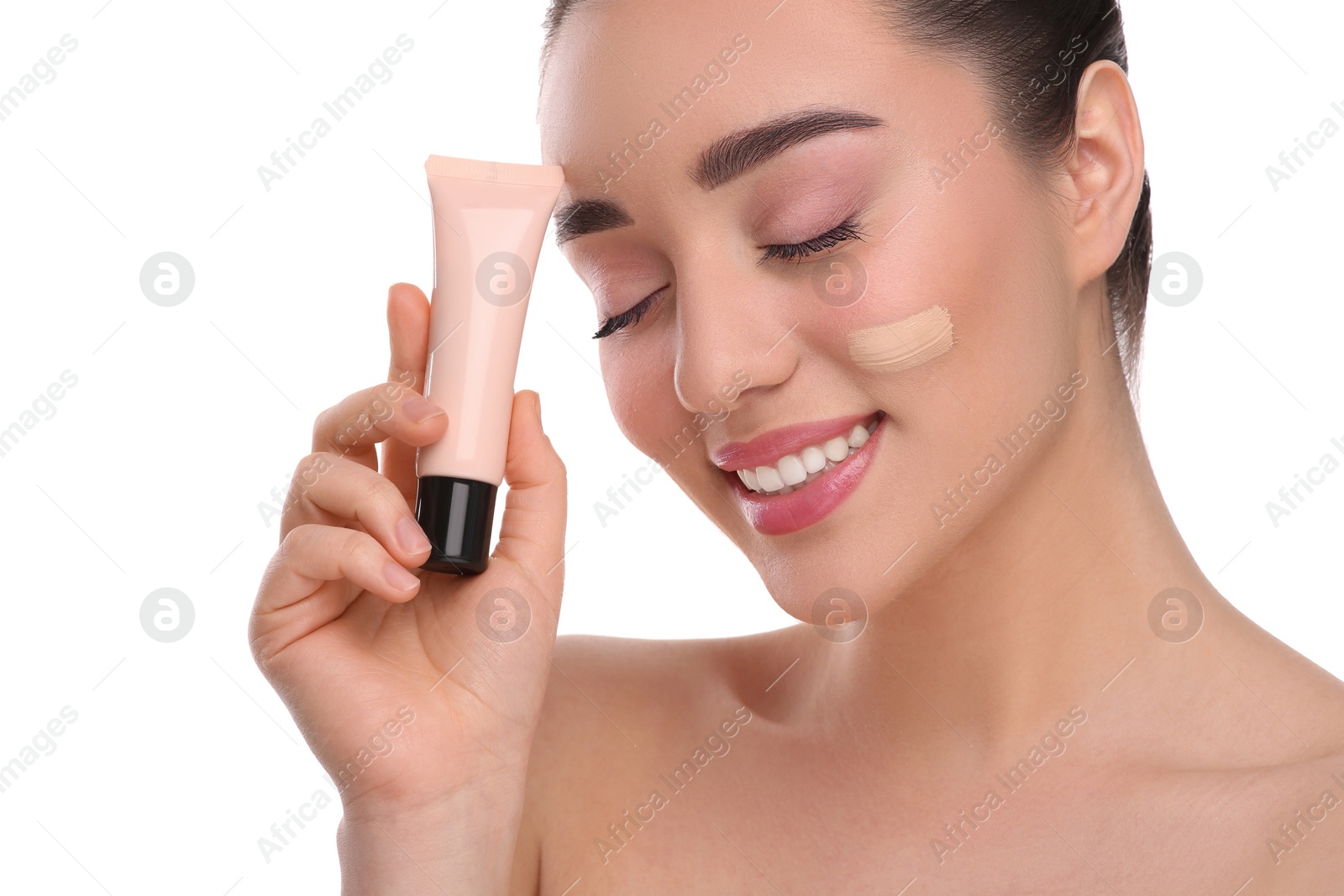 Photo of Woman holding tube of foundation on white background