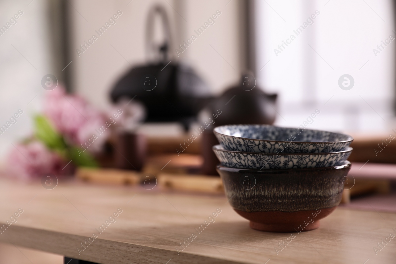 Photo of Stack of cups for traditional tea ceremony on wooden table