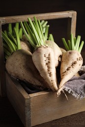 Photo of Basket with fresh sugar beets on wooden table, closeup