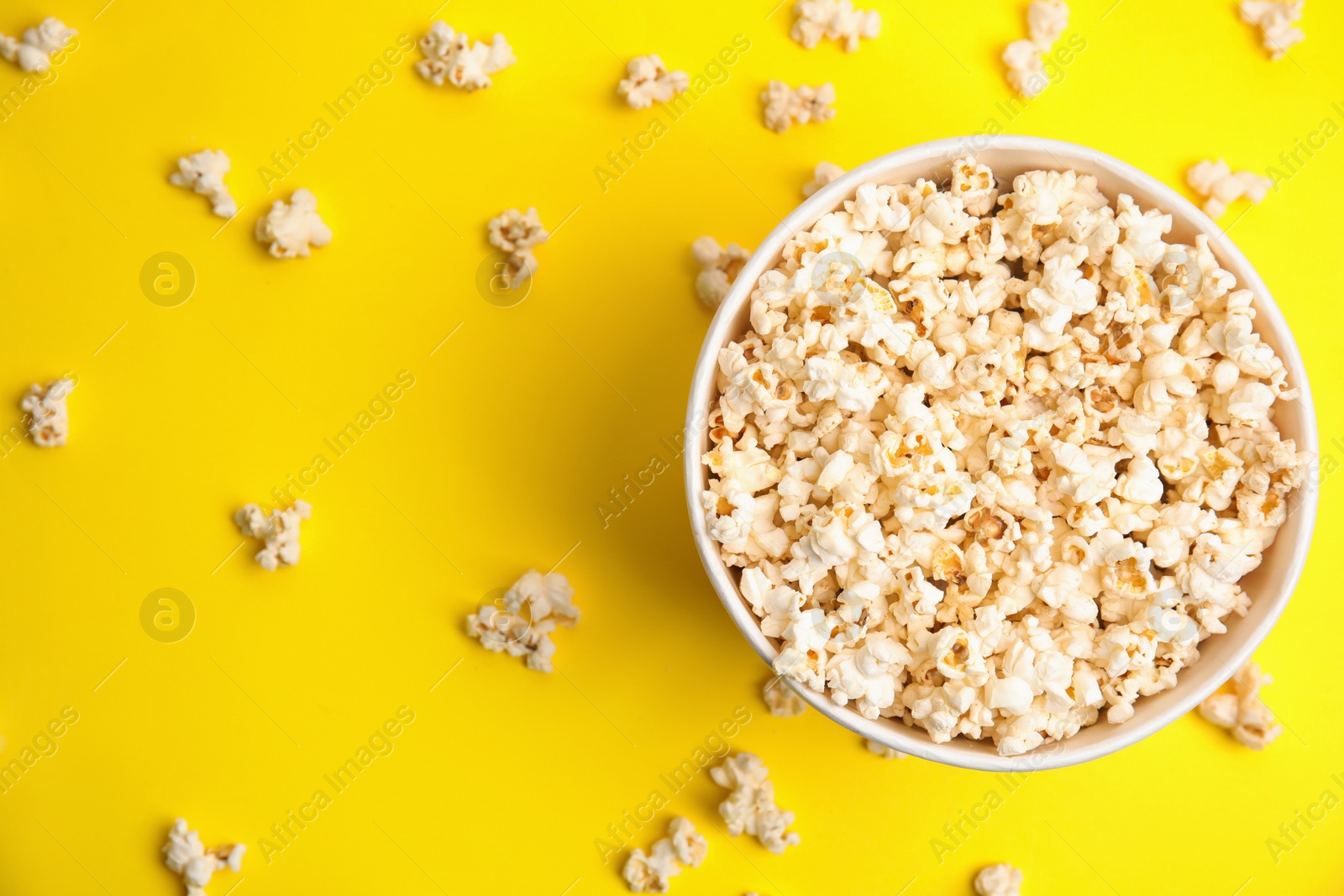 Photo of Tasty pop corn on yellow background, flat lay