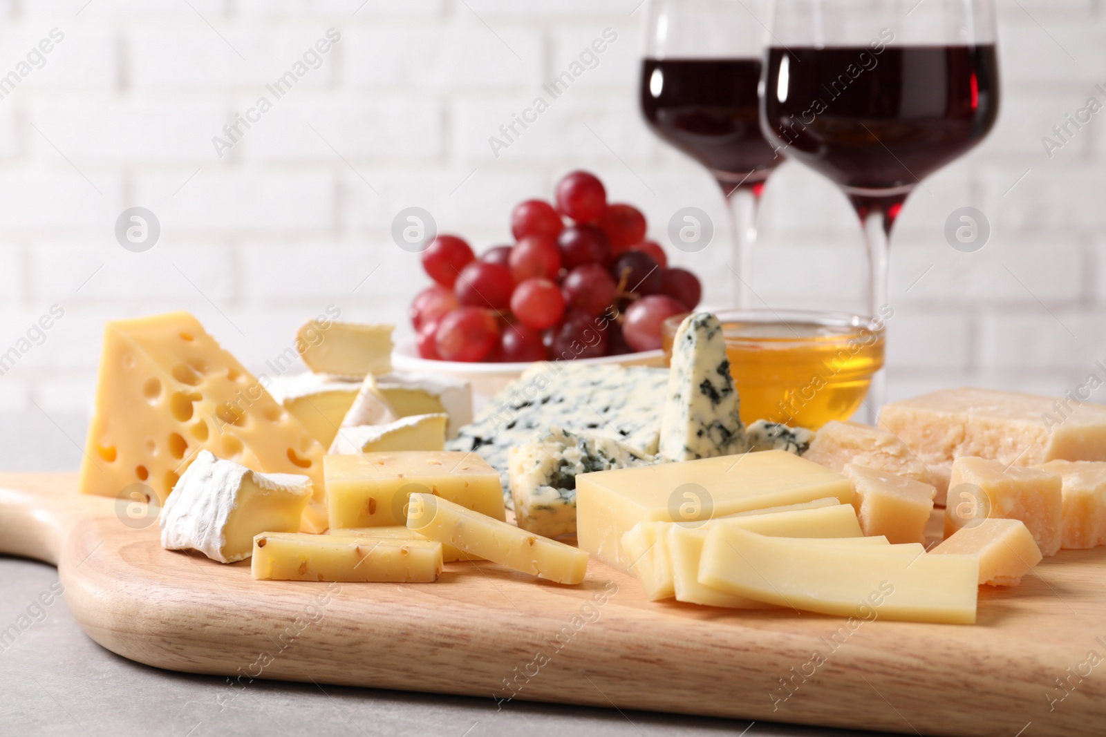 Photo of Plate with different sorts of cheese on grey table, closeup