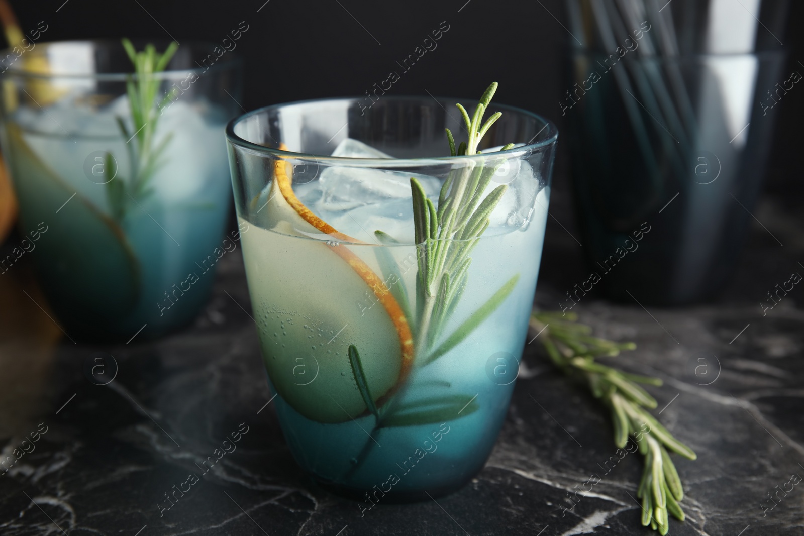 Photo of Tasty refreshing pear cocktail with rosemary on table