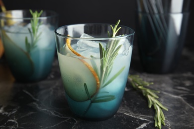 Photo of Tasty refreshing pear cocktail with rosemary on table