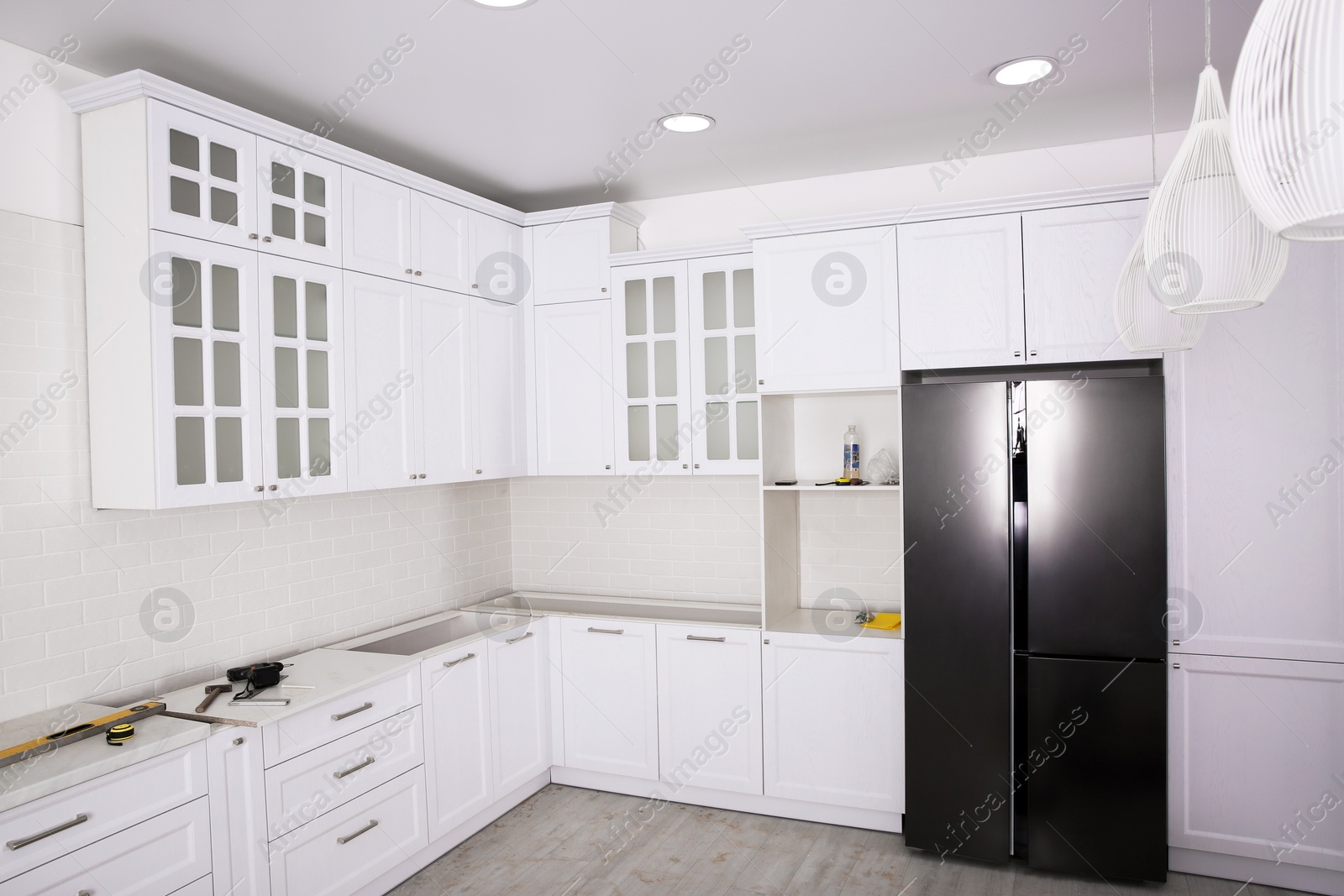 Photo of Renovated kitchen interior with stylish furniture, refrigerator and maintenance equipment