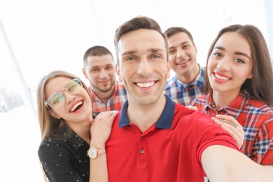 Happy friends taking selfie indoors