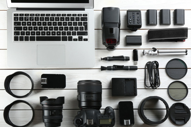 Photo of Flat lay composition with equipment for professional photographer on white wooden table