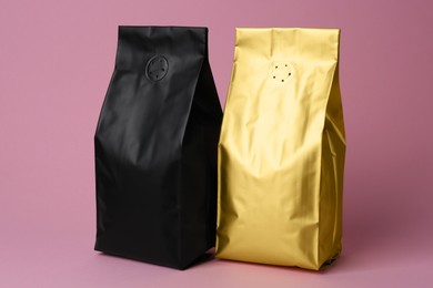 Photo of Different blank foil packages on pink background