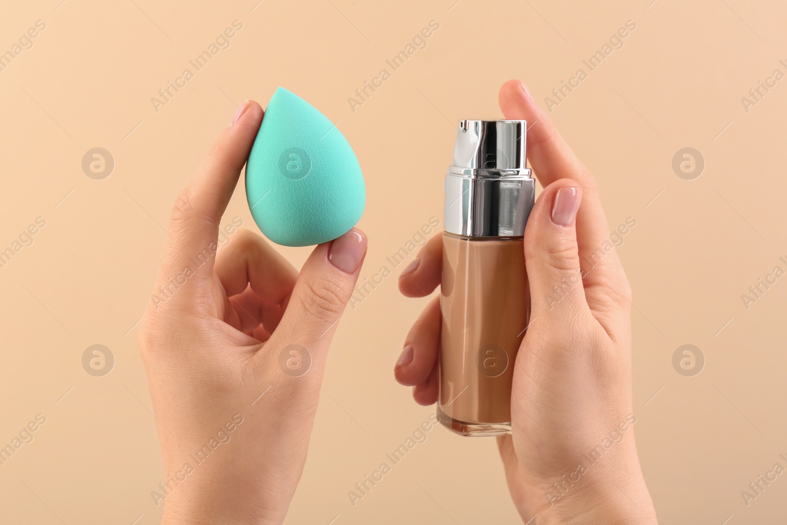 Photo of Woman with makeup sponge and skin foundation on beige background, closeup