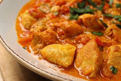 Photo of Delicious chicken curry with parsley on table, closeup