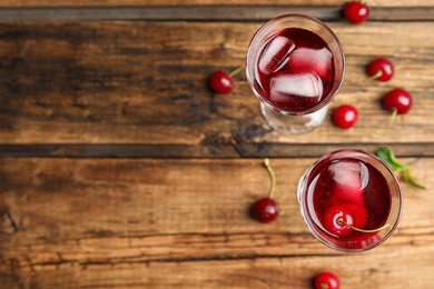 Photo of Delicious cherry wine with ripe juicy berries on wooden table, flat lay. Space for text