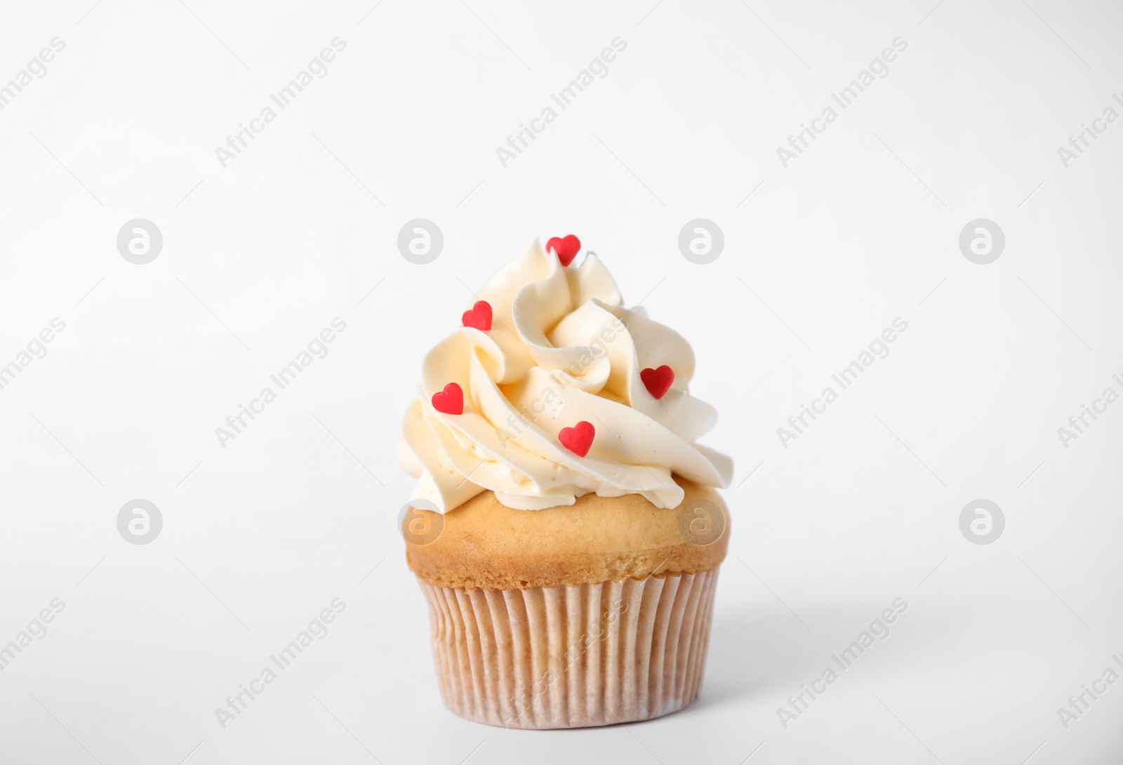 Photo of Tasty cupcake with heart shaped sprinkles for Valentine's Day on white background