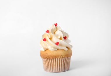 Photo of Tasty cupcake with heart shaped sprinkles for Valentine's Day on white background