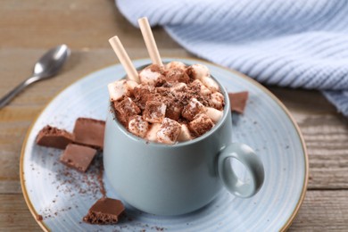 Photo of Cup of aromatic hot chocolate with marshmallows and cocoa powder served on table, closeup