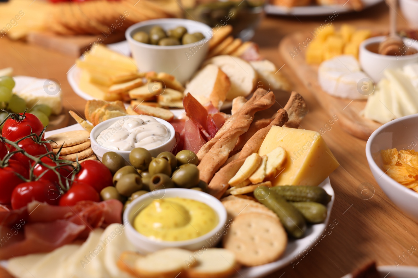 Photo of Assorted appetizers served on wooden table, closeup