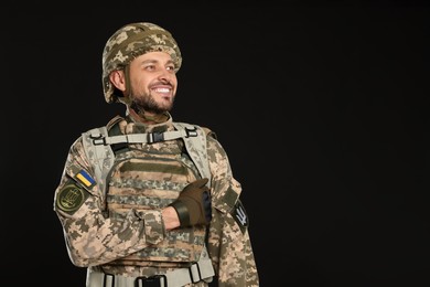 Photo of Soldier in Ukrainian military uniform on black background. Space for text