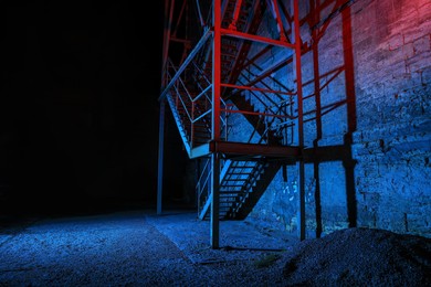 Photo of Old building with fire escape at night