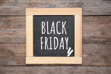Image of Blackboard with text BLACK FRIDAY and pieces of chalk on wooden background, top view