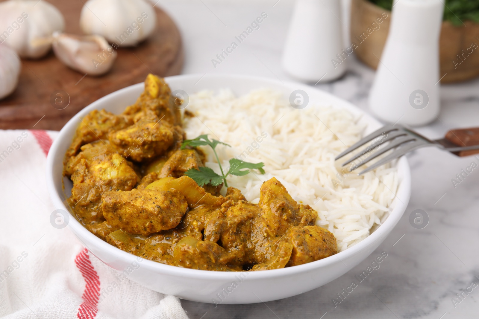 Photo of Delicious chicken curry with rice on white marble table, closeup