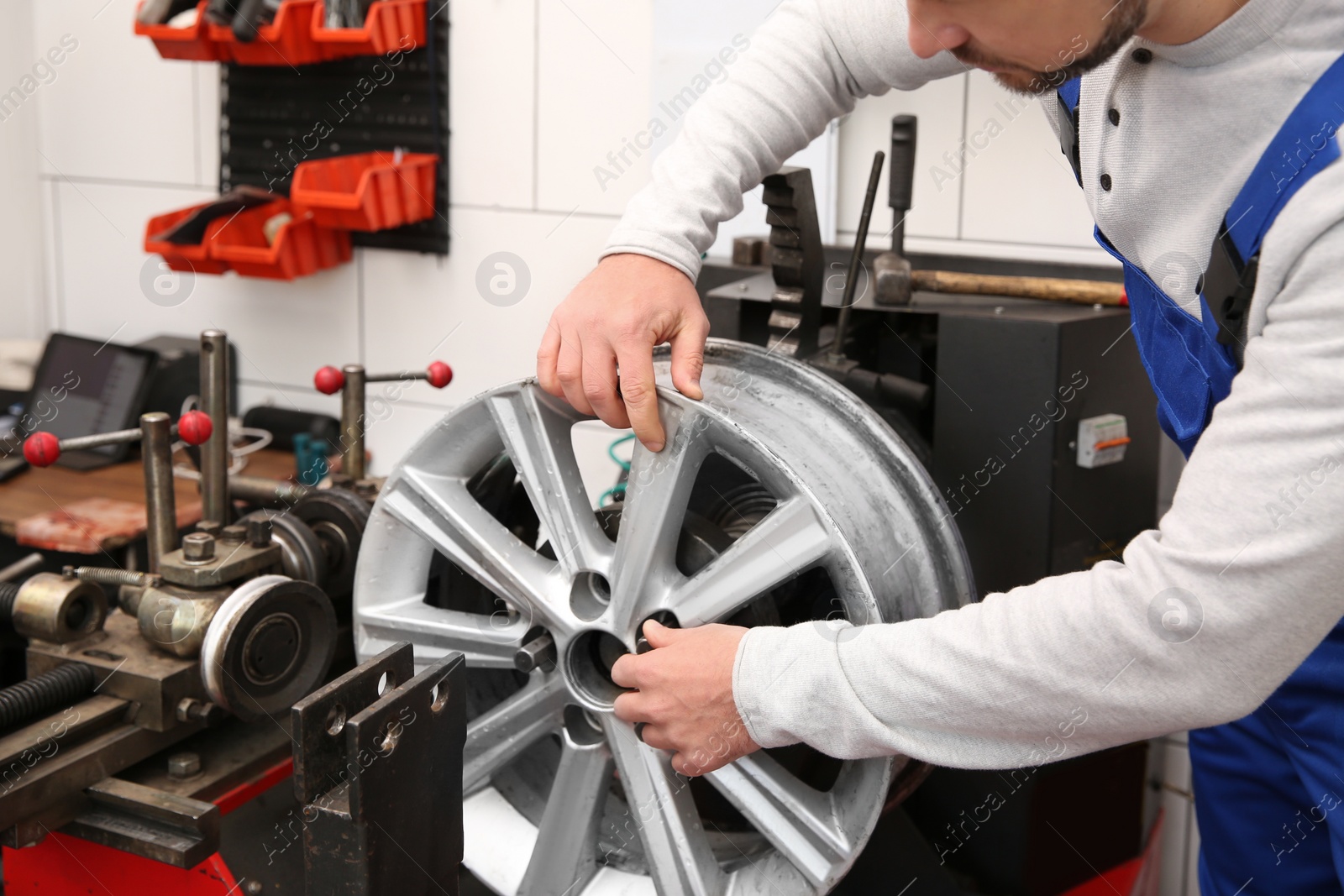 Photo of Mechanic working with car disk lathe machine at tire service, closeup