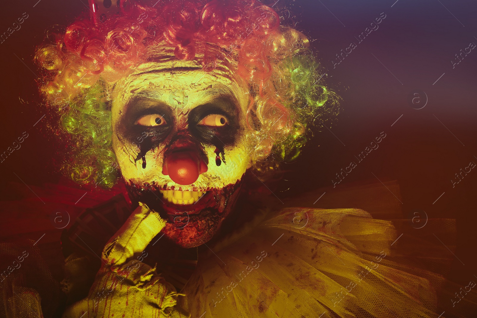 Photo of Terrifying clown in darkness. Halloween party costume