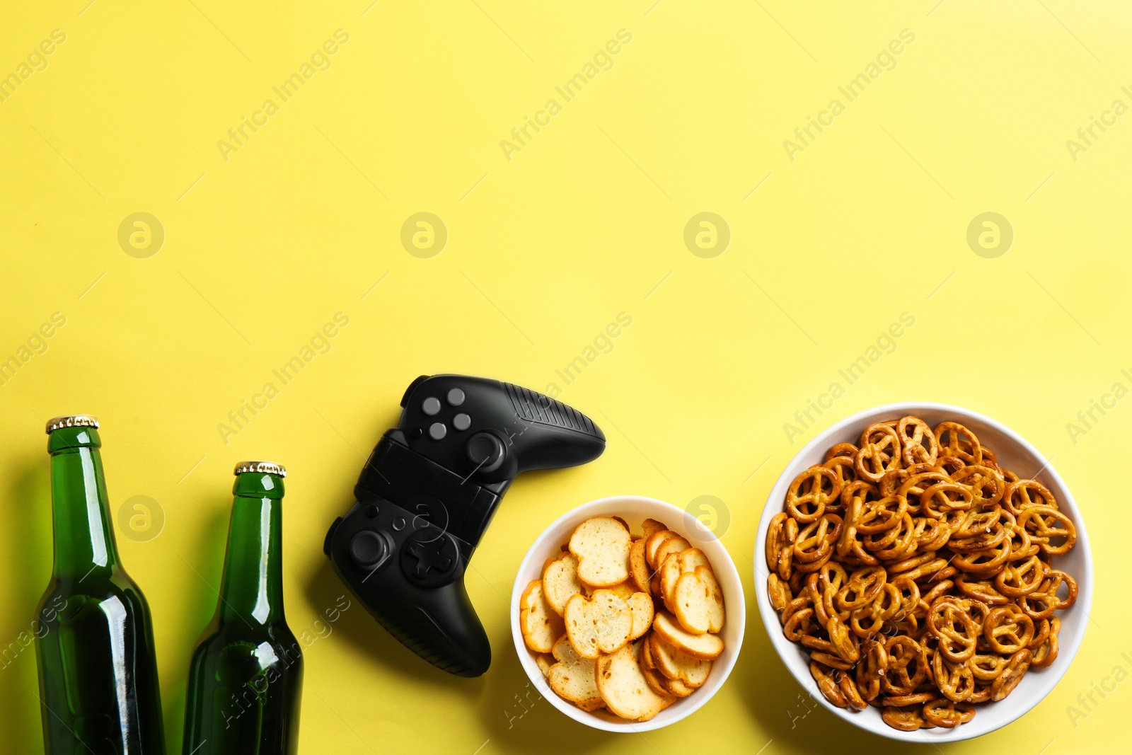 Photo of Flat lay composition with video game controller, snacks and space for text on color background