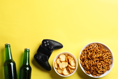 Flat lay composition with video game controller, snacks and space for text on color background