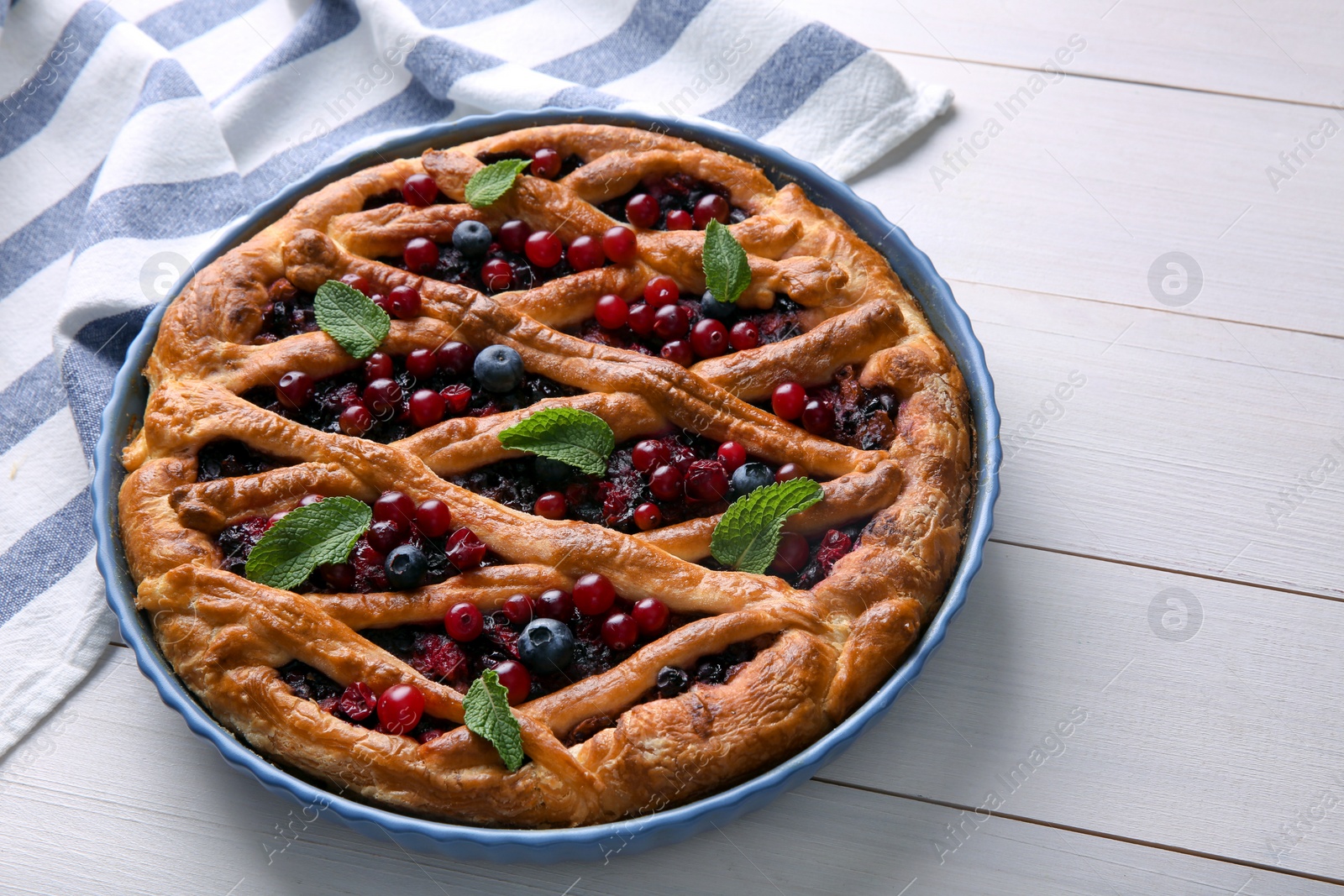 Photo of Delicious currant pie and fresh berries on white wooden table