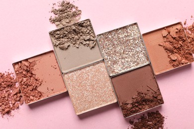 Photo of Crushed eye shadows on pink background, flat lay. Professional makeup product