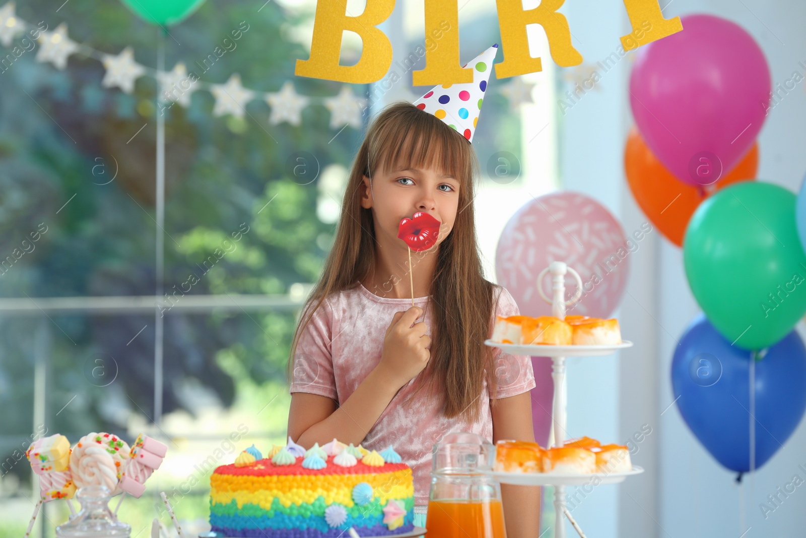 Photo of Happy girl in room decorated for birthday party