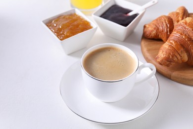 Photo of Breakfast time. Fresh croissants, jams and coffee on white table. Space for text