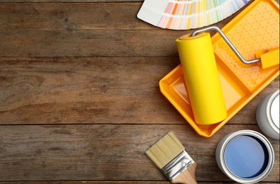 Photo of Flat lay composition with can of paint, brush and renovation tools on wooden background. Space for text